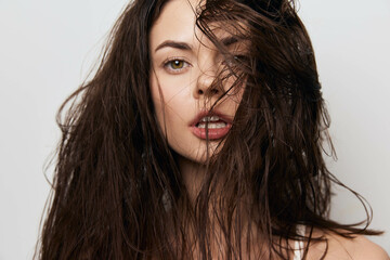 Woman with wet hairstyle and expressive gaze, featuring tousled hair, captivating expression on a...