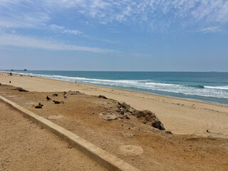 Wide view of a sunny beach coastline on a bright summer day in June in Huntington Beach, SoCal, Southern California, USA