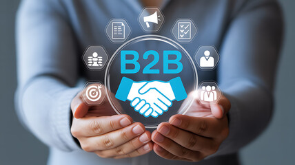 Person holding a b to b graphic with icons around it in their hands in a studio shot