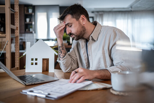 Architect feeling stressed while working at home on housing project