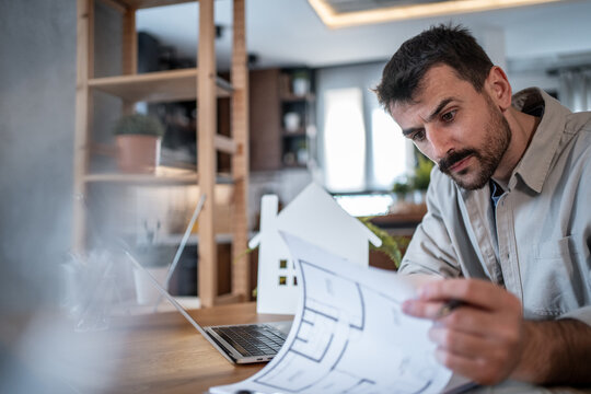 Architect reviewing blueprints for a new residential building project