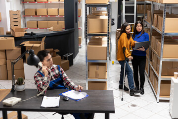 Asian worker with physical disability contributes to retail operations by preparing packages in a...
