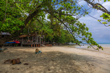 Trees on Kai Bae Beach under a blue sky with clouds on Koh Chang Island