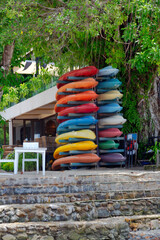 Stack of typical thai colorful kayaks stand on the seashore on Koh Chang island
