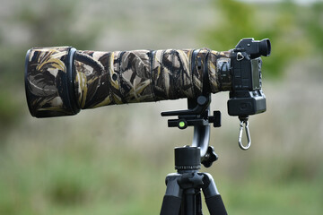Camera on a tripod with a telephoto lens