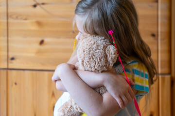 little child, preschool girl 5 years old plays with toy, hugs teddy bear, happy childhood, emotional support in early years, emotional attachment, childhood psychology