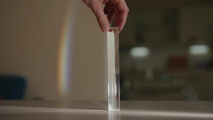 Man spinning triangular glass prism, light passes through creating beautiful rainbow on wall, demonstrating physics principles of refraction and dispersion. Shooting in slow motion. - Powered by Adobe