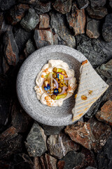 Feta Cheese Hummus with Roasted Olives on stones