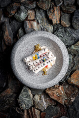 Delicate Mascarpone Vanilla Cream with Strawberry, Sumac, and Crispy Meringue on stones