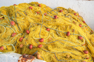 Vibrant fishing nets and buoys piled on a dock, ready for the sea, closeup
