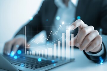 Person in suit using laptop with rising graph overlay indicating business growth trend