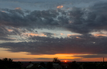 Landscape at sunset. Tragic gloomy sky. Panorama. Crimson twilight.