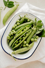 Fresh green peas in a white plate, healthy snack