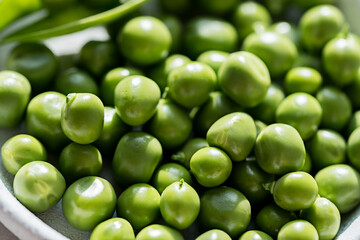 Close-up fresh green peas beans in a white plate. Macro photography