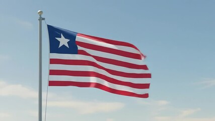 The Liberian national flag fluttering in the morning breeze, centered against a soft, clear blue sky.