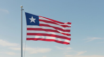 The Liberian national flag fluttering in the morning breeze, centered against a soft, clear blue sky.