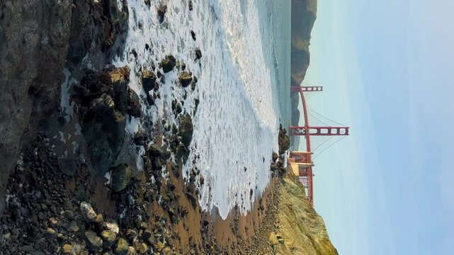 Sunset view on Golden gate bridge from Baker beach. Bay area. San Francisco landmark, travel destination, Vertical footage