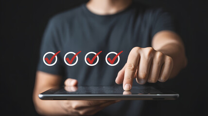 Person uses a tablet for a digital checklist, marking tasks with red checkmarks, showing progress and efficiency in project management.