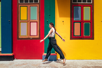 Young woman walking in front of colorful houses in Little India, Singapore © NoemiEscribano