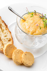Delicious yellow caviar in a bowl with croutons and butter on plate isolated on white background. Fish and seafood, close up, top view