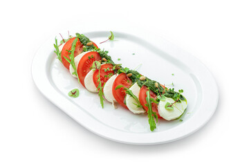 Fresh italian Caprese salad with tomatoes, mozzarella cheese and basil in plate isolated on white background, top view, close up