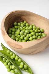 Fresh ripe green peas on white wooden table, closeup