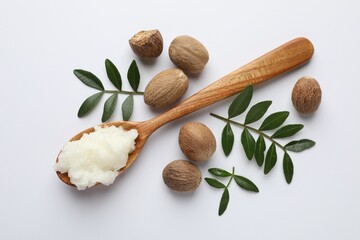Shea butter, nuts and leaves on white background, flat lay