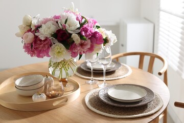 Beautiful table setting with bouquet of peonies in dining room, closeup