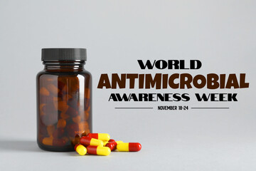 World antibiotic awareness week. Bottle and scattered pills on grey background