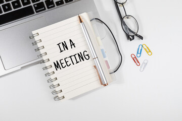 Office Note “In a Meeting” Set on Office Desk – Status Notification Concept