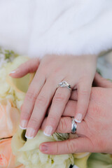 Couple shares a tender moment showcasing wedding rings and flowers during a celebration of love outdoors
