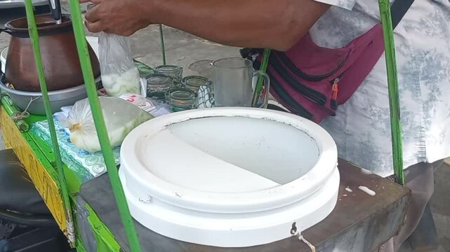 Video footage of a cendol dawet seller making an order, a refreshing Indonesian dessert 