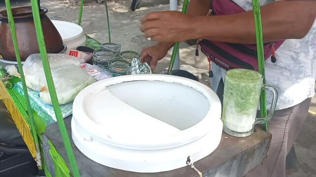 Video footage of a cendol dawet seller making an order, a refreshing Indonesian dessert 