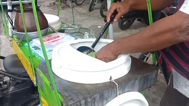 Video footage of a cendol dawet seller making an order, a refreshing Indonesian dessert 