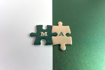 A concept photo illustrating Merger and Acquisition (M&A), represented by interlocking green and...