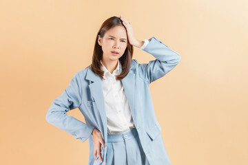 Unhealthy Asian businesswoman touching body and have a headache on beige color background.