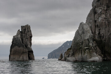 Bering Strait. Eastern coast of Chukotka. In the foreground is Cape Kekurny. In the distance is Cape Wigven (North-Eastern). Arctic seascape with harsh cliffs. Chukotka Peninsula, Russian Far East.