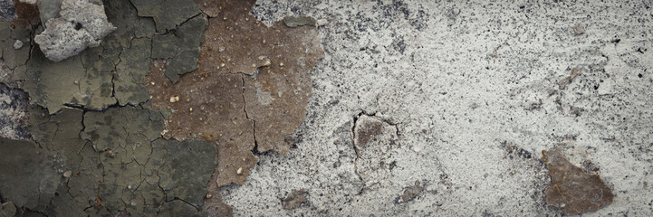 Peeling paint on the wall. Panorama of a concrete wall with old cracked flaking paint. Weathered...