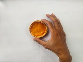 The right hand holds a delicious milk pie with a white background. This milk pie is typical of...