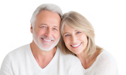 A joyful senior couple smiling warmly at the camera. showcasing their love and connection. set against a soft. neutral background. perfect for themes of aging gracefully and companionship