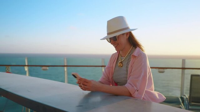 A vibrant and lively scene beautifully capturing a cheerful woman on a cruise ship, joyfully taking selfies against the breathtaking backdrop of a stunning sunset over the vast ocean horizon