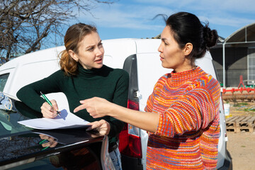 Woman signs the documents for the delivery of the goods to the farm field
