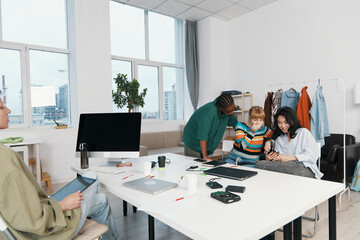 young adult colleagues working together in modern workplace socializing and collaborating as friends and coworkers during business meeting