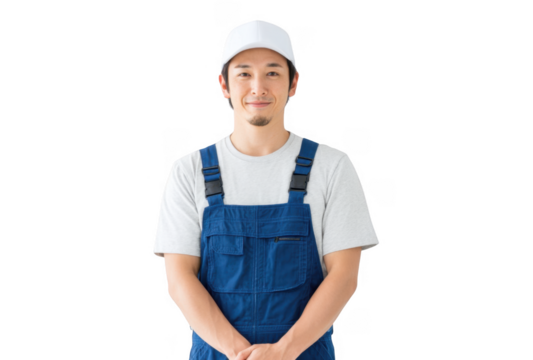 A cheerful young man in blue overalls and a white cap poses confidently against a plain white background. showcasing a friendly demeanor suitable for a variety of professional or personal contexts