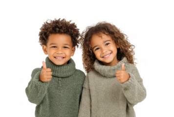 Two cheerful children giving thumbs up while wearing cozy sweaters. standing against a plain white background. conveying joy and positivity. ideal for family or children's fashion themes