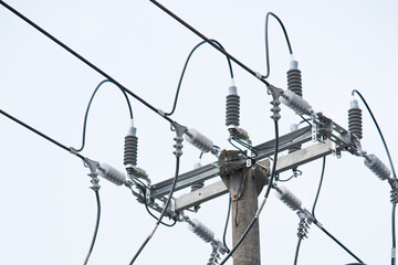 A typical electricity pole in Indonesia, heavily laden with numerous power lines, a transformer,...