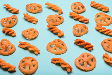 Various shapes of crispy seasoned flour duritos arranged on a pastel blue background
