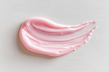 Pink cream swatch on white backdrop exhibits textural lines and highlights creating a sleek cosmetic appeal