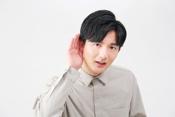 男性　耳に手を当てて聴く　20代　白背景