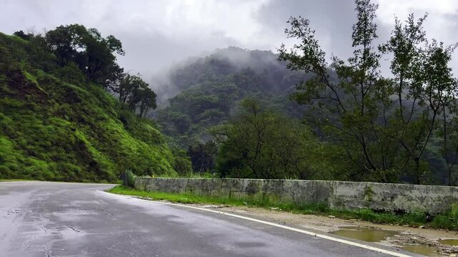 Scenic road through winding mountain road surrounded by rainy tropical forest in charmadi karnataka india